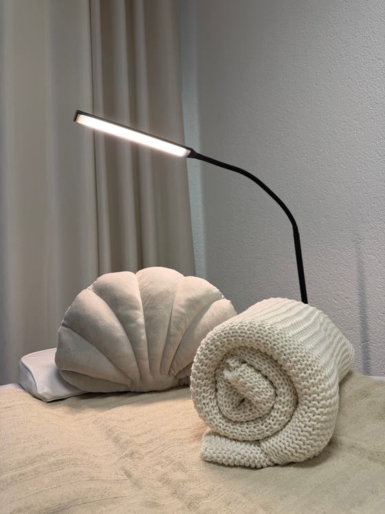 Behandlungsliege mit Kissen und Lampe